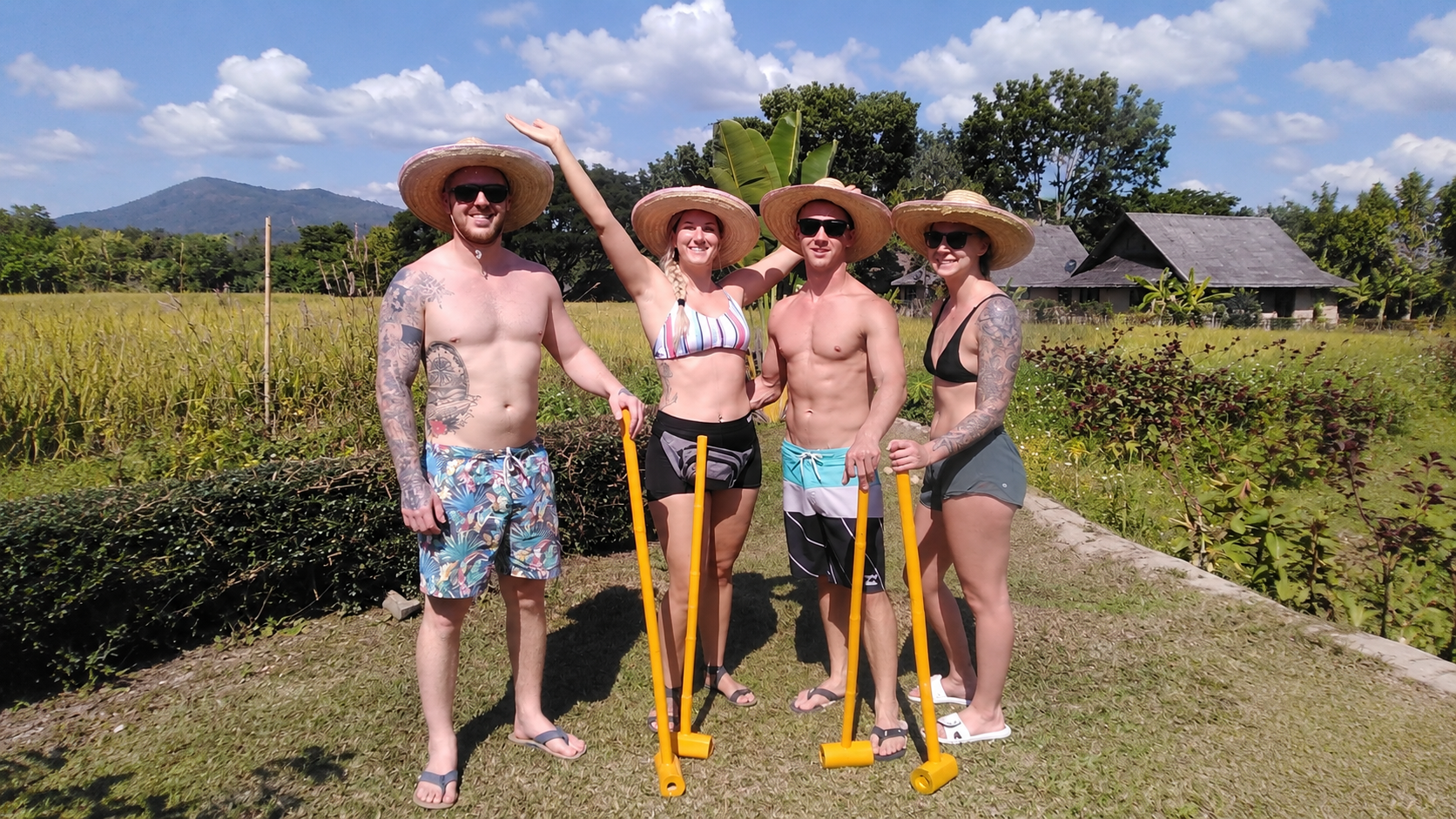 Visitors with bamboo mini golf clubs surrounded by Pai mountain scenery